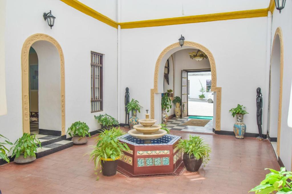 a courtyard with a fountain in the middle of a building at Tembo House Hotel in Zanzibar City