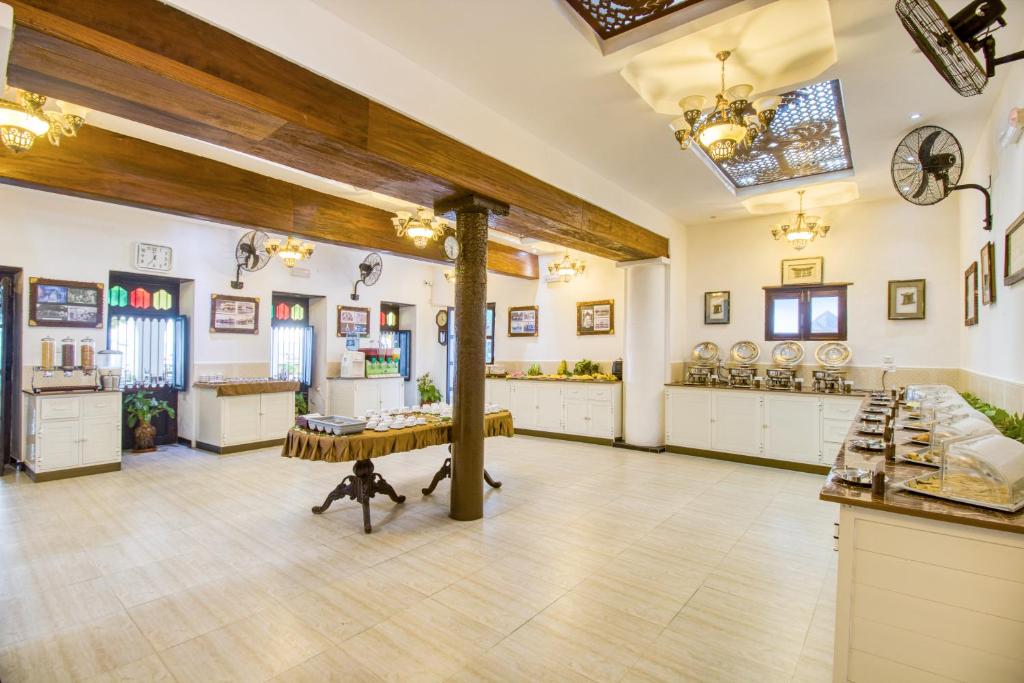 a large kitchen with wooden beams and white cabinets at Tembo House Hotel in Zanzibar City