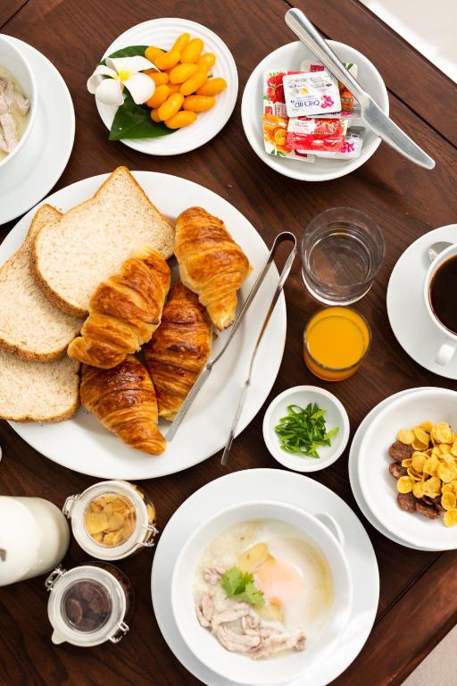 A close breakfast spread with croissants, toast, cereal, fruit, and drinks.
