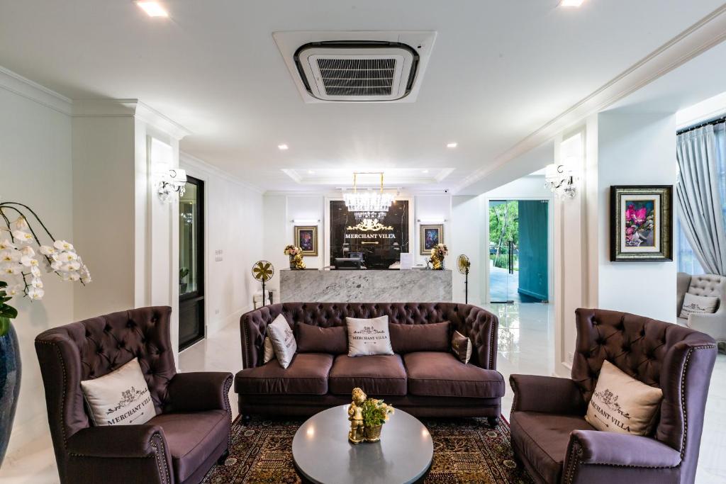 A formal sitting area with velvet armchairs, a sofa, and a reception desk.