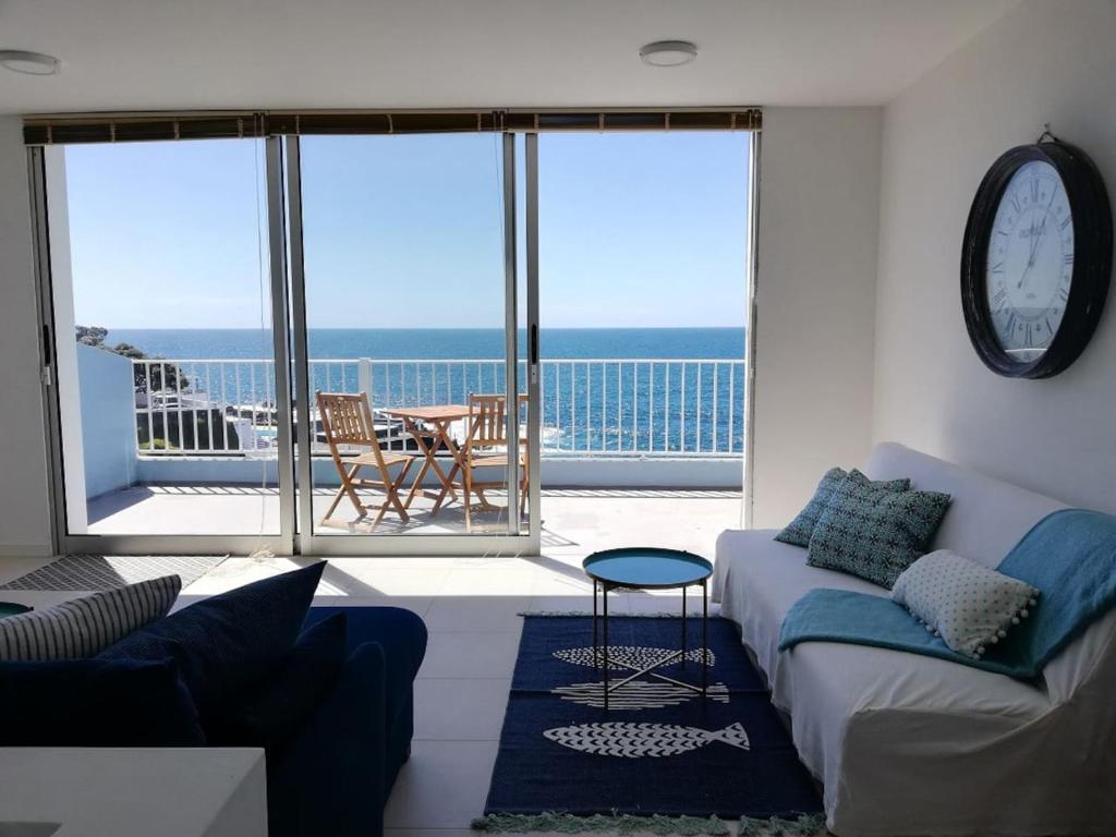 a living room with a couch and a view of the ocean at La Dolce Vita in Lagoa