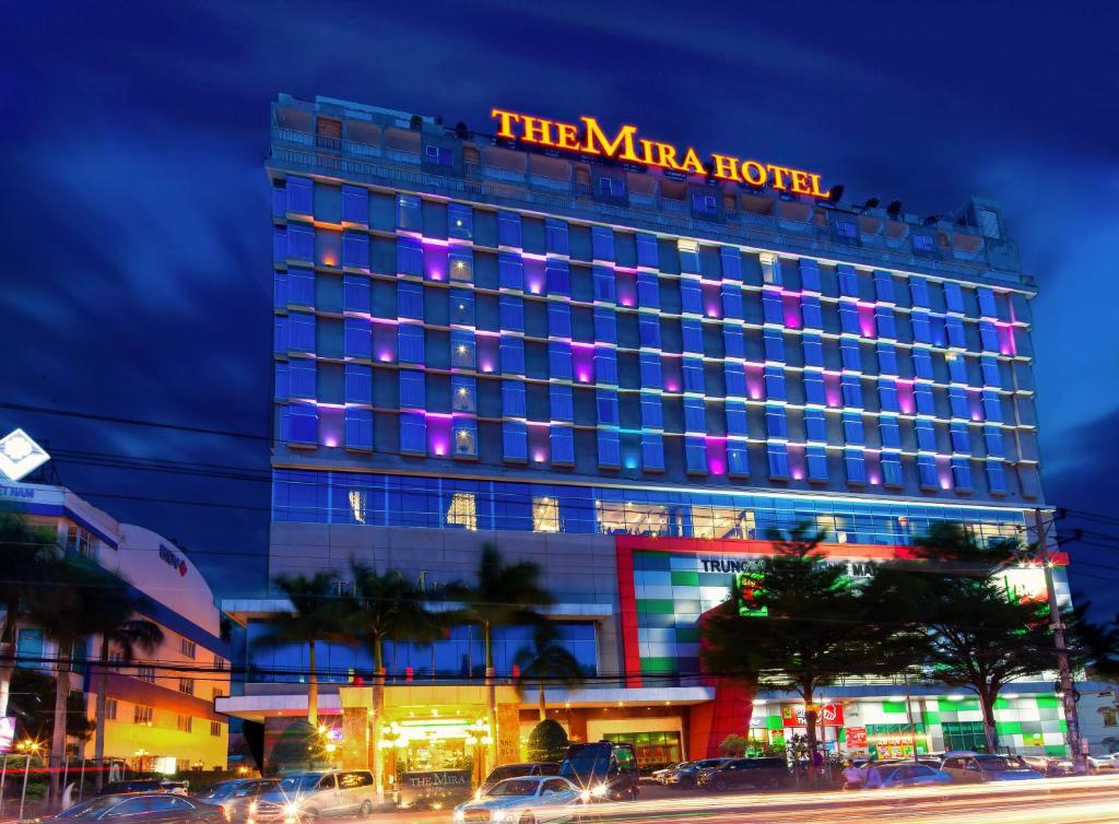 un bâtiment d'hôtel avec un panneau en haut dans l'établissement The Mira Hotel, à Thu Dau Mot