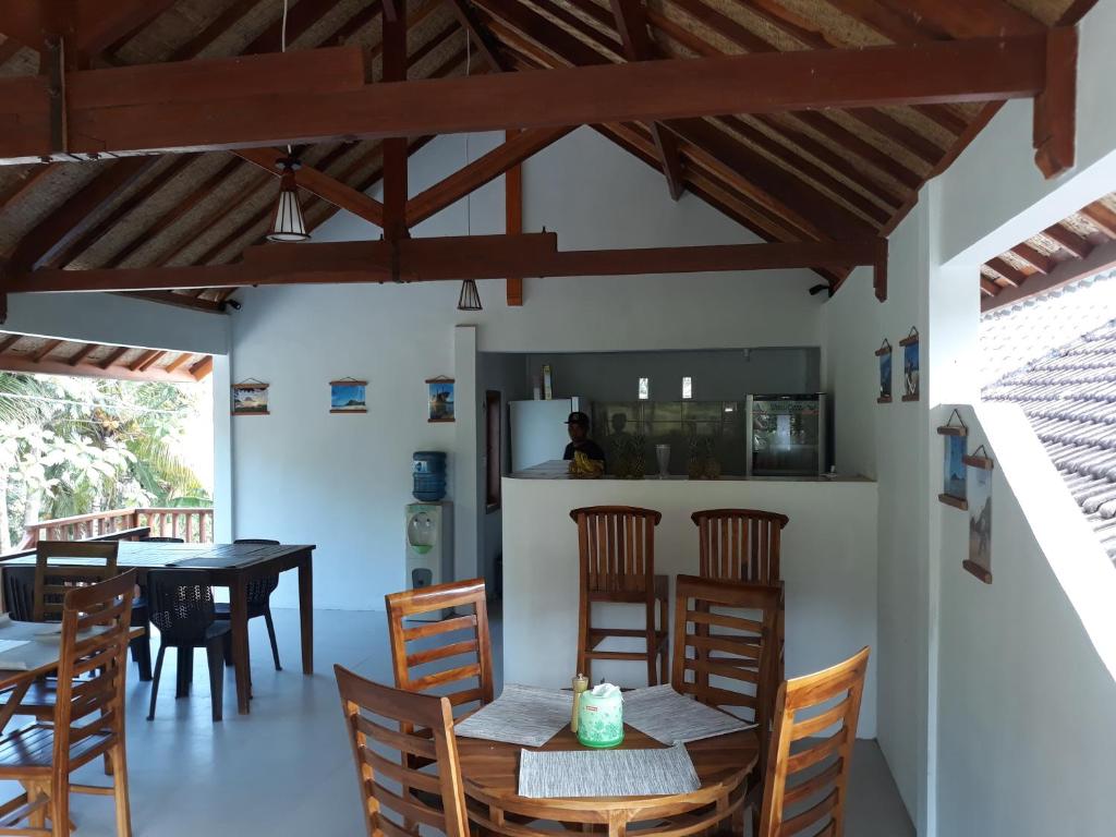 uma sala de jantar com cadeiras de madeira e uma mesa em Serah's Homestay em Kuta