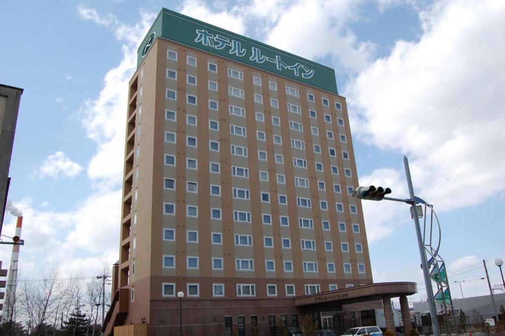 un edificio alto con un cartel encima en Hotel Route-Inn Tomakomai Ekimae en Tomakomai