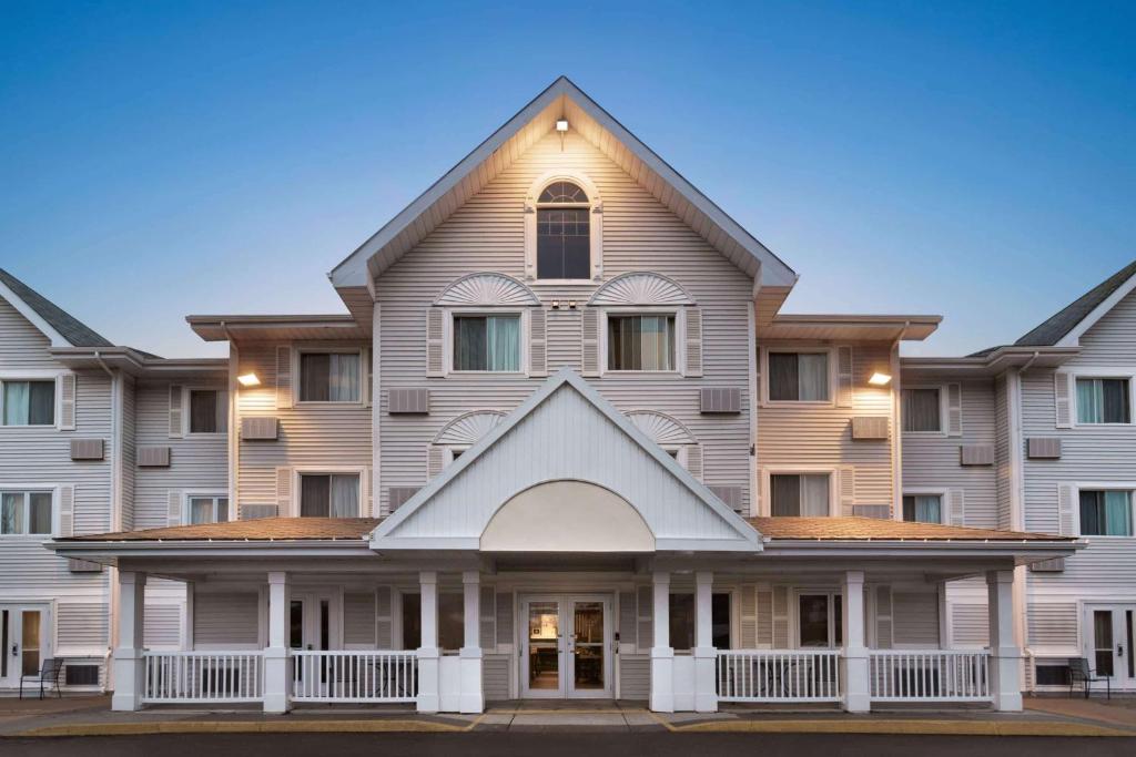 un grand immeuble d'appartements avec un gambrel dans l'établissement Travelodge Suites by Wyndham Moncton, à Moncton