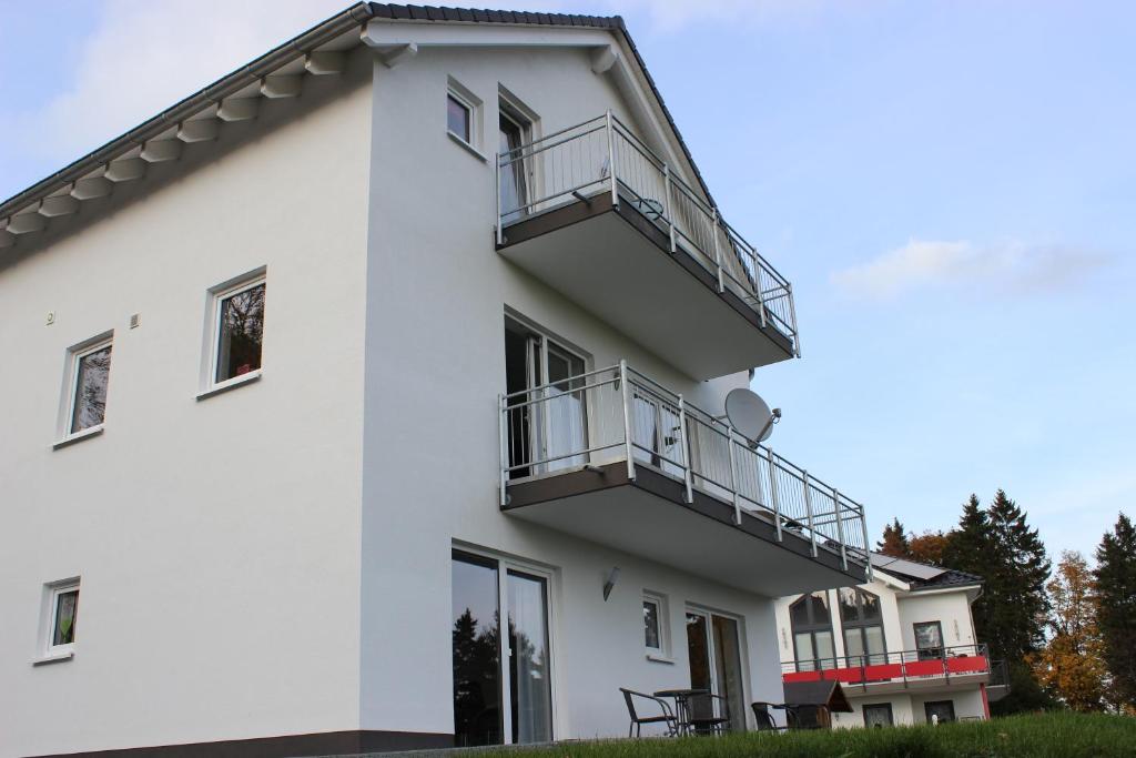 una casa blanca con balcones. en Appart-Hotel Harmonie, en Winterberg