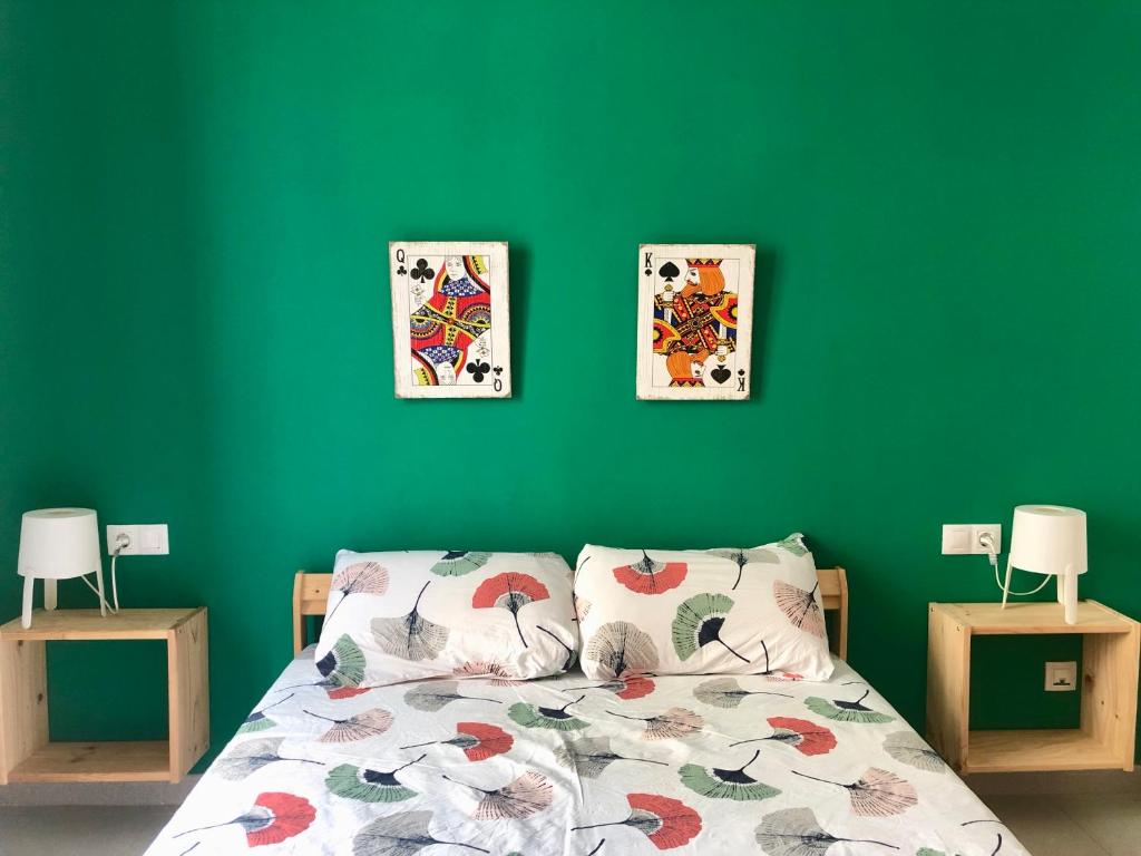 1 dormitorio verde con 1 cama y 2 cuadros en la pared en Apartament Centre ciutat, en Tarragona