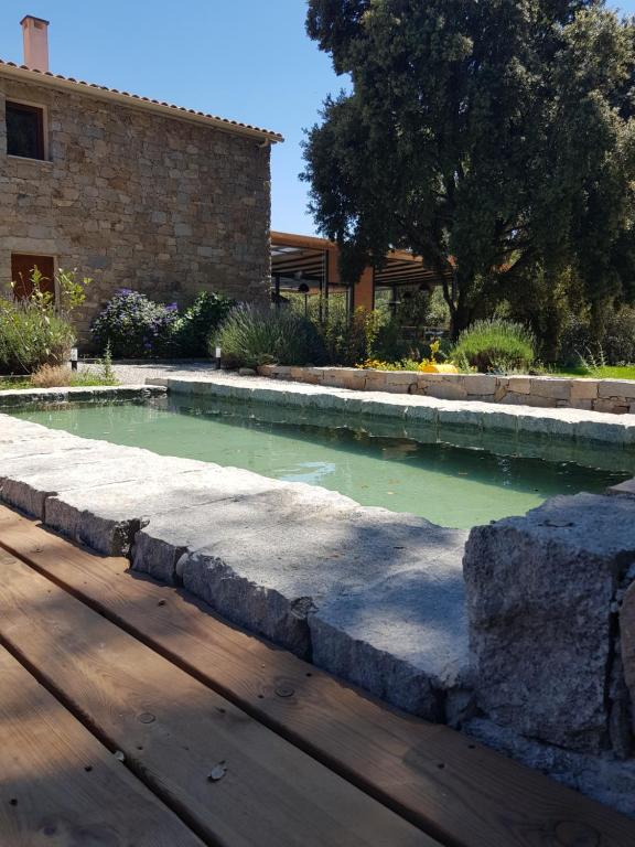 a pool of water next to a building at Maison d'Hôtes Zella in Bains de Guitera
