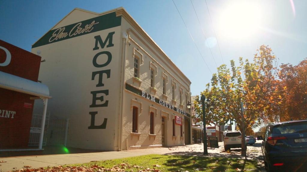 a large building with a sign on the side of it at Elm Court Motel in Albury