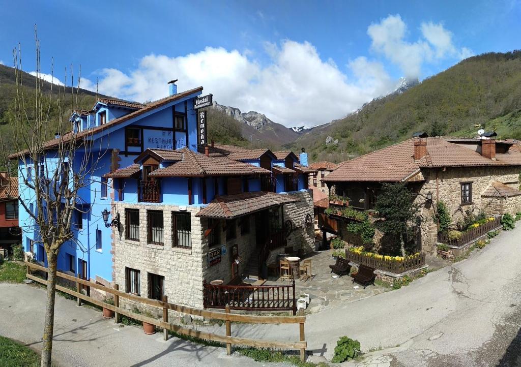 a blue and white building with mountains in the background at Hostal Remoña in Espinama