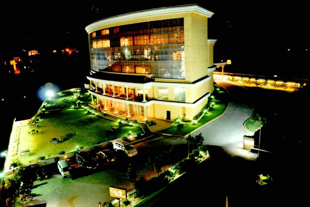 un gran edificio con luces delante de él por la noche en K C Residency, en Katra