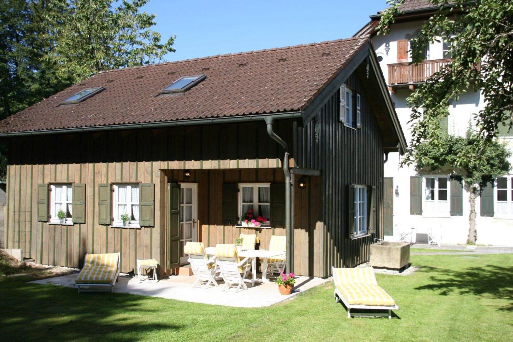a barn with a table and chairs in a yard at Ferienhaus Alp Chalet in Kochel