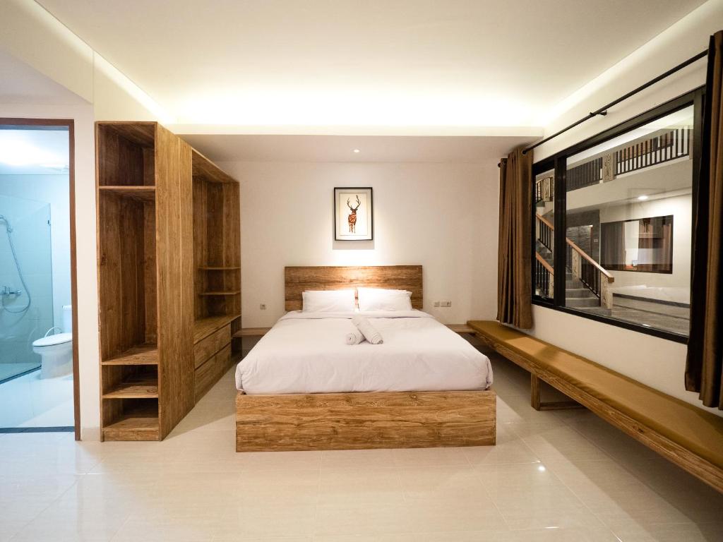 a bedroom with a bed and a television in it at Metta Agara in Kerobokan