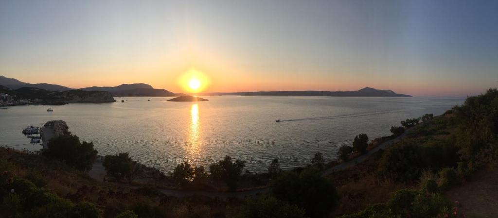 a sunset over a large body of water at Ansi Studios & Apartments in Almirida