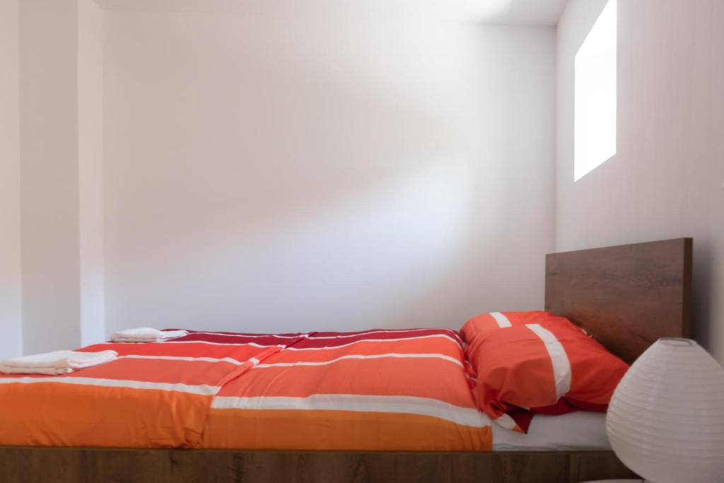a bedroom with a bed with orange and white sheets at Demix in Koper