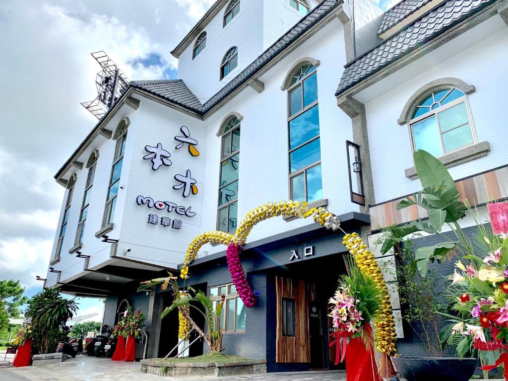 um edifício com um ramo de flores à frente dele em Roppongi Motel - JianHua em Pingtung