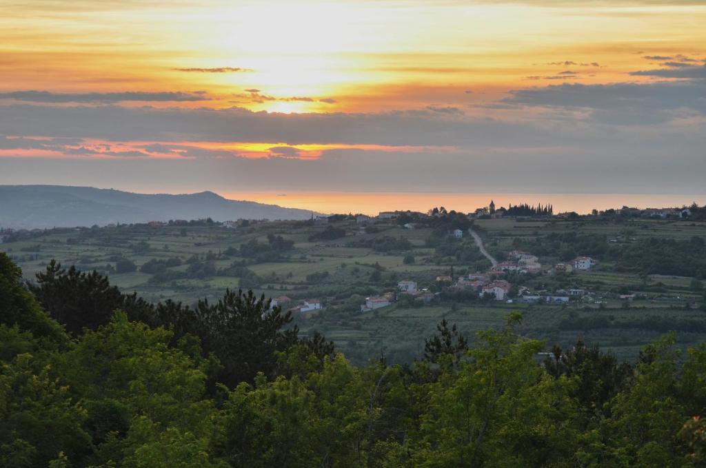 a view of a valley with the sunset in the background at Guesthouse Green Istria in Truške