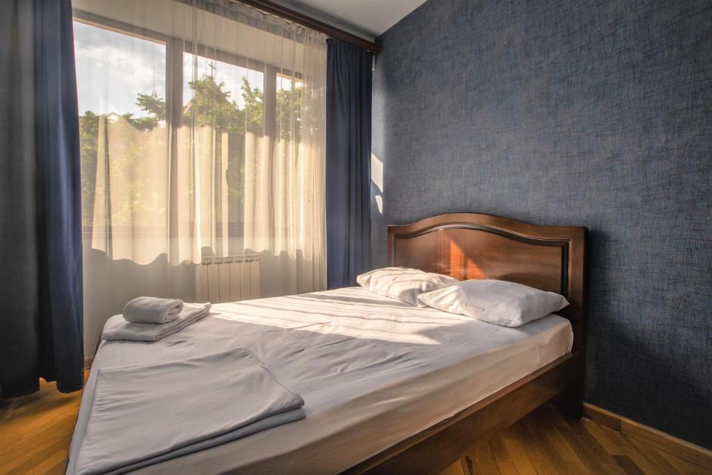 a bed in a bedroom with a large window at Stay Inn Apartments at Abovyan Street in Yerevan