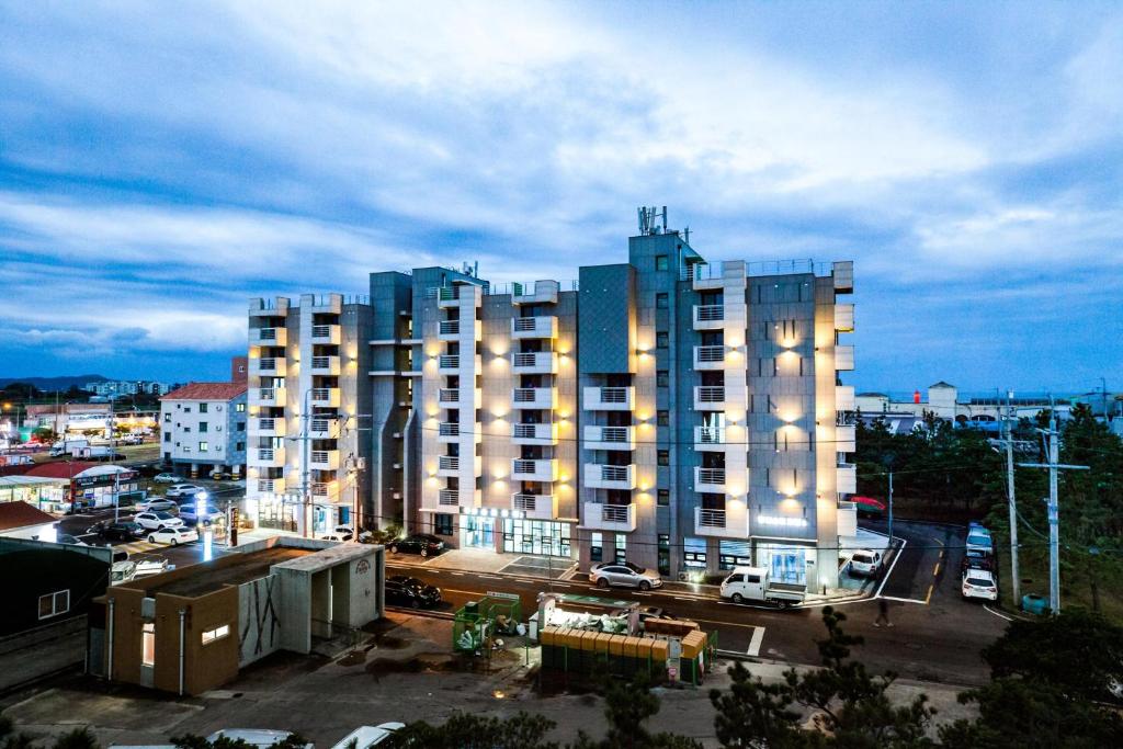 a large building with lights on in a city at Jeju Moseulpo Hotel in Seogwipo