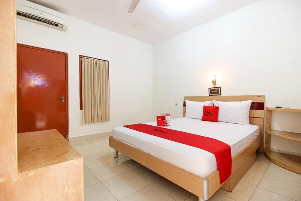 a bedroom with a large bed in a room at RedDoorz Syariah At Jalan Menteri Supeno in Yogyakarta