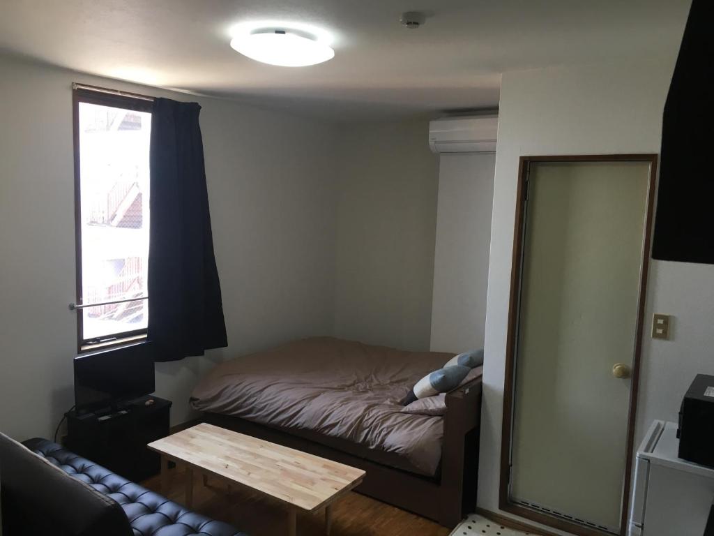 małą sypialnię z łóżkiem i lustrem w obiekcie コンドミニアムホテル Stay inn Blue 301号室 w mieście Hukue