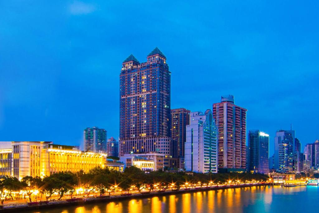 un perfil urbano por la noche con un río y edificios en Guangzhou Seaman Club en Cantón