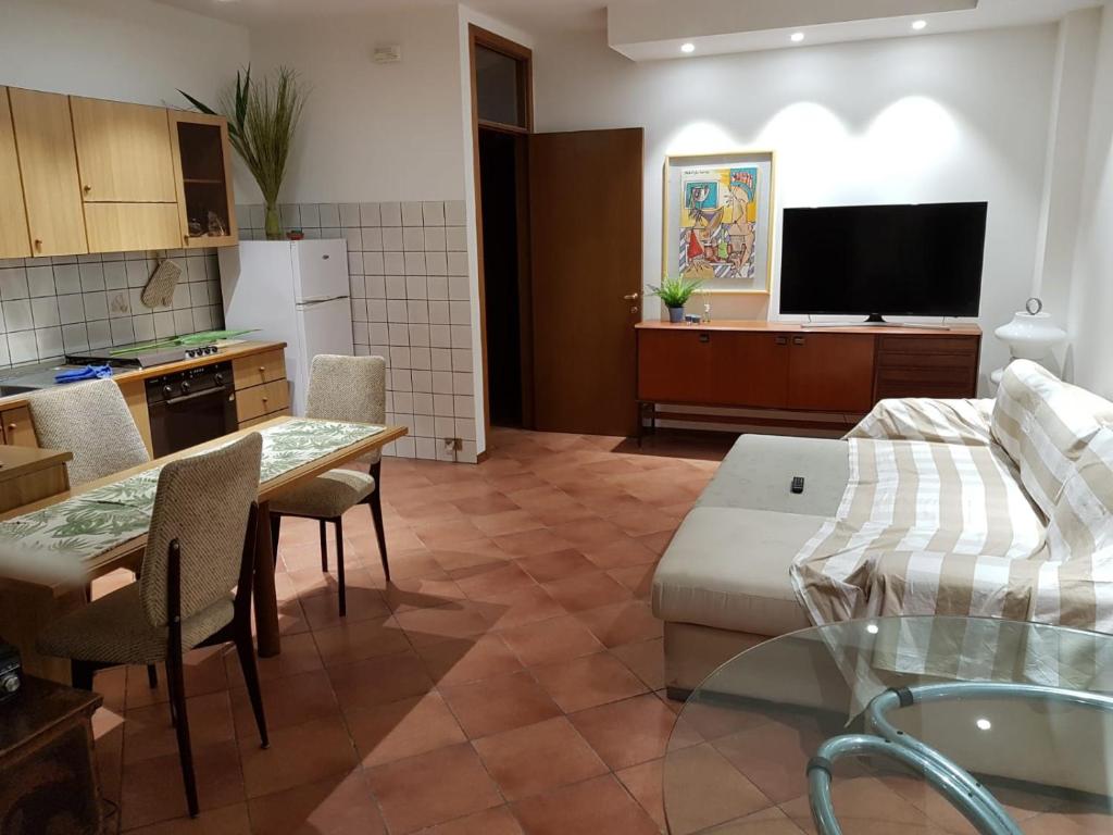 Il dispose d'une cuisine et d'un salon avec une table et un canapé. dans l'établissement Porto Recanati Apartament, à Porto Recanati