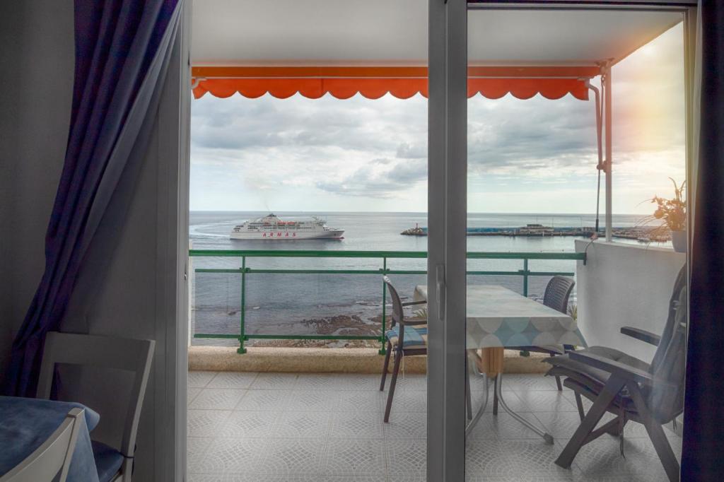 a balcony with a view of the ocean and a cruise ship at Comodoro Estudio Vista Mar Explotaciones Ravel in Arona