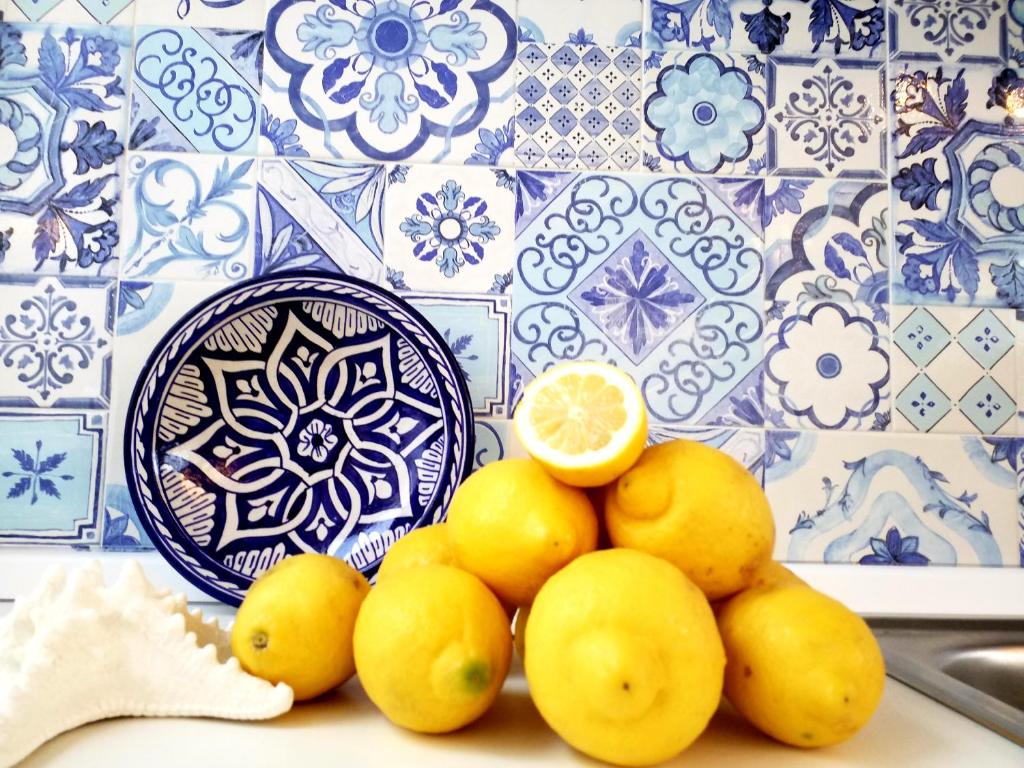 a pile of lemons on a plate with a blue and white at Mediterranean Apartments in Capo dʼOrlando