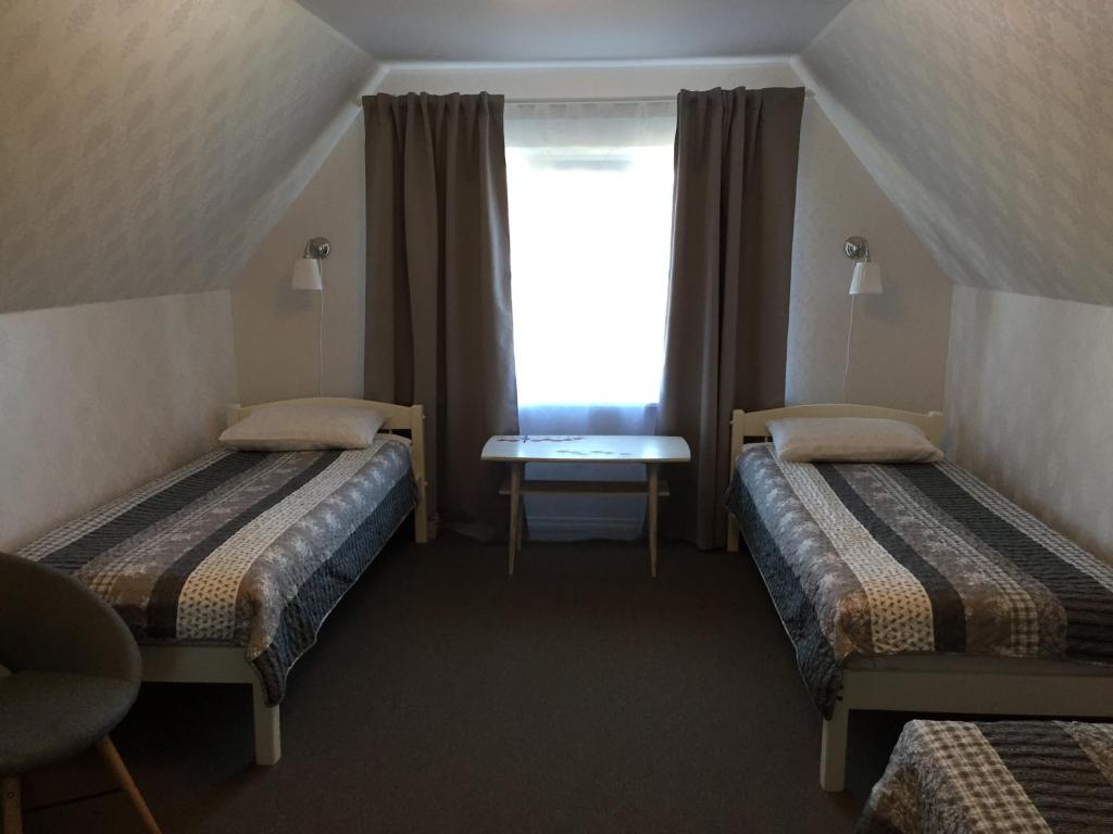 Habitación pequeña con 2 camas y ventana en Tiigi Accommodation, en Kärdla