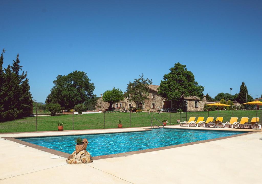 un osito de peluche sentado junto a una piscina en Masia Can Solà Gros en Caldes de Malavella