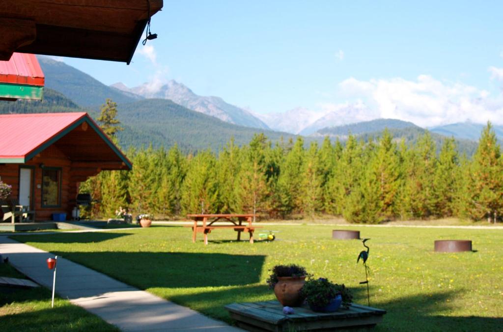 a yard with a picnic table and mountains in the background at Twin Peaks Resort in Valemount