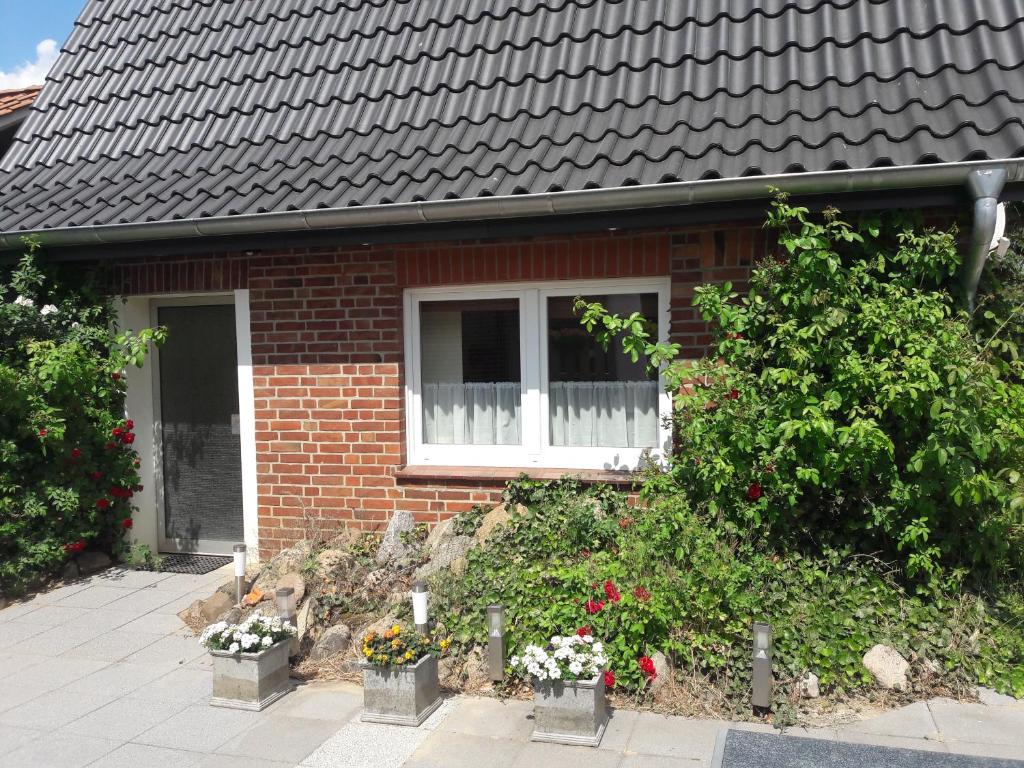 a brick house with a window and some flowers at Ferienhaus Bavendorf in Thomasburg