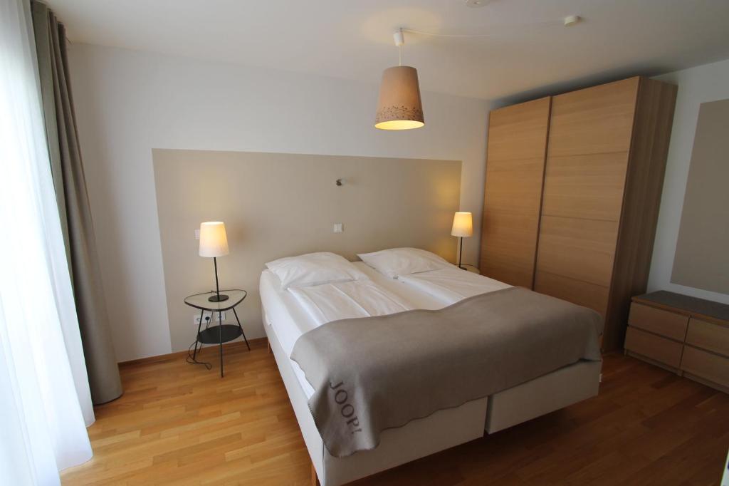 ein Schlafzimmer mit einem großen Bett und einem Nachttisch in der Unterkunft Park Linné Management GmbH in Köln
