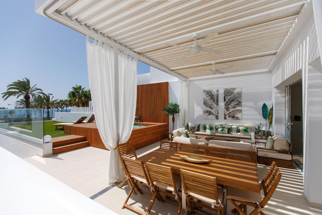 a patio with a wooden dining table and a couch at Villa con piscina en Pasito PM34 in Pasito Blanco