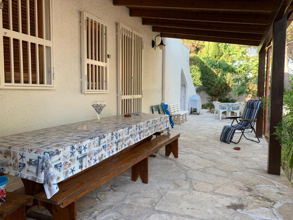 um pátio de pedra com uma mesa e cadeiras numa casa em Villa Maria em Torre Lapillo