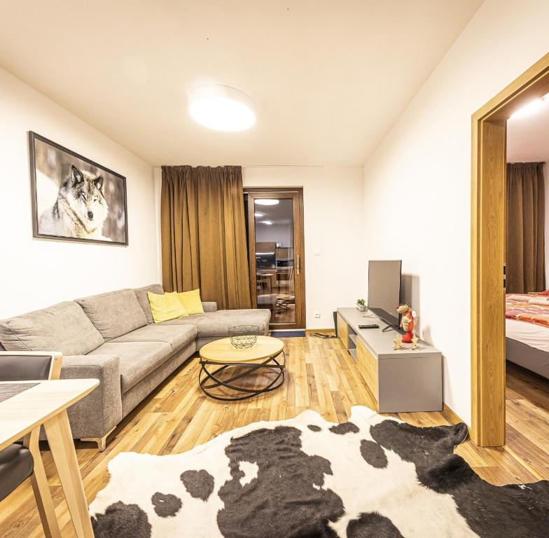 a living room with a couch and a table at Apartmánový dom Poludnica - Chopok Juh in Tale