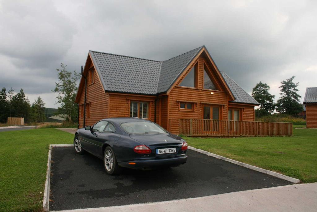 a car parked in a parking lot in front of a house at Drumcoura Lake Resort, Pet Friendly, Wifi, SKY TV, 4 Bedrooms, 2 reception rooms in Drumcoura