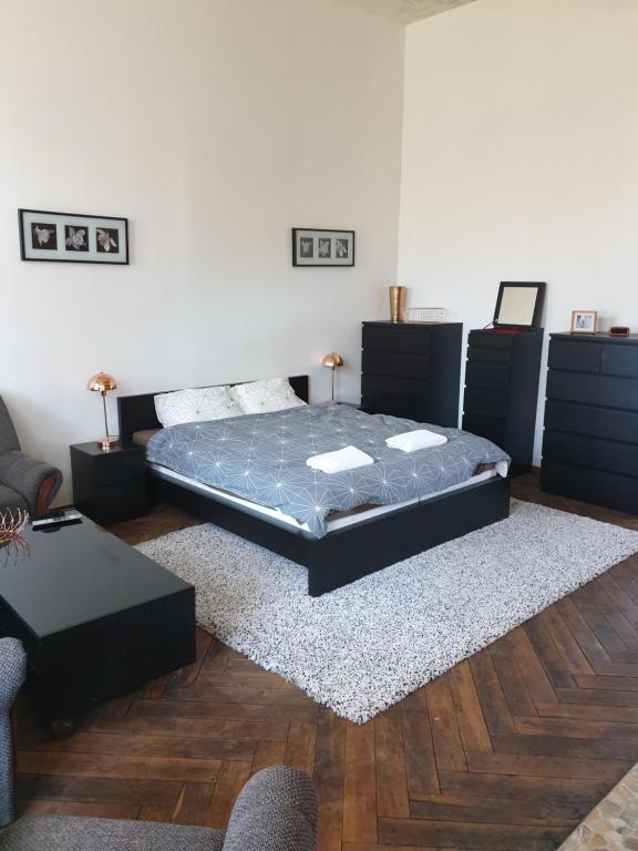 a bedroom with a bed and a couch and a table at Bartas apartment in Liepāja