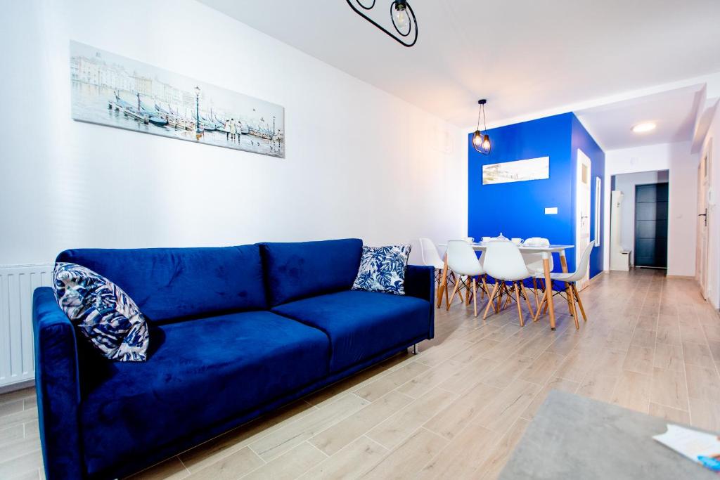 Sofá azul en la sala de estar con mesa en Apartamenty Sun Seasons 24 - Posesja Bałtycka, en Grzybowo