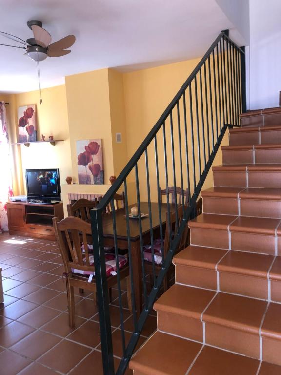 una escalera en una casa con mesa y sillas en Casa Rural Valverde 6, en El Real de la Jara