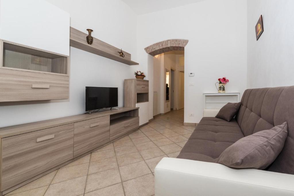 ein Wohnzimmer mit einem Sofa und einem Flachbild-TV in der Unterkunft Finalborgo - Casa Nanetti 6 posti in centro in Finale Ligure