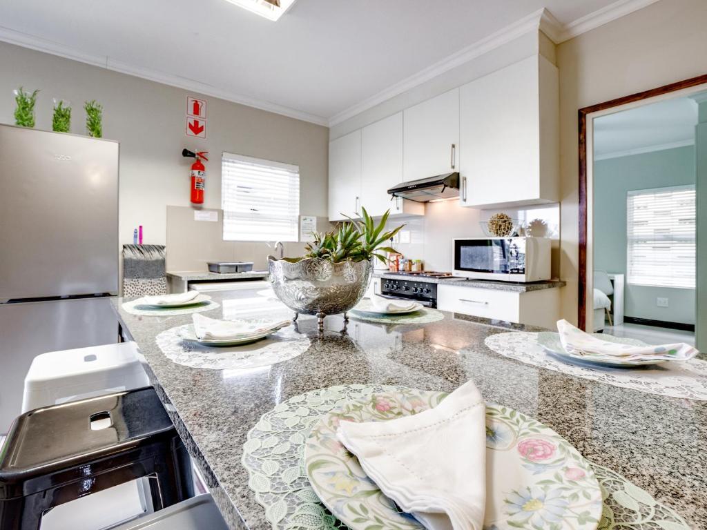 a kitchen with white cabinets and a granite counter top at Westwood Skye 12 Grace Avenue in Durban