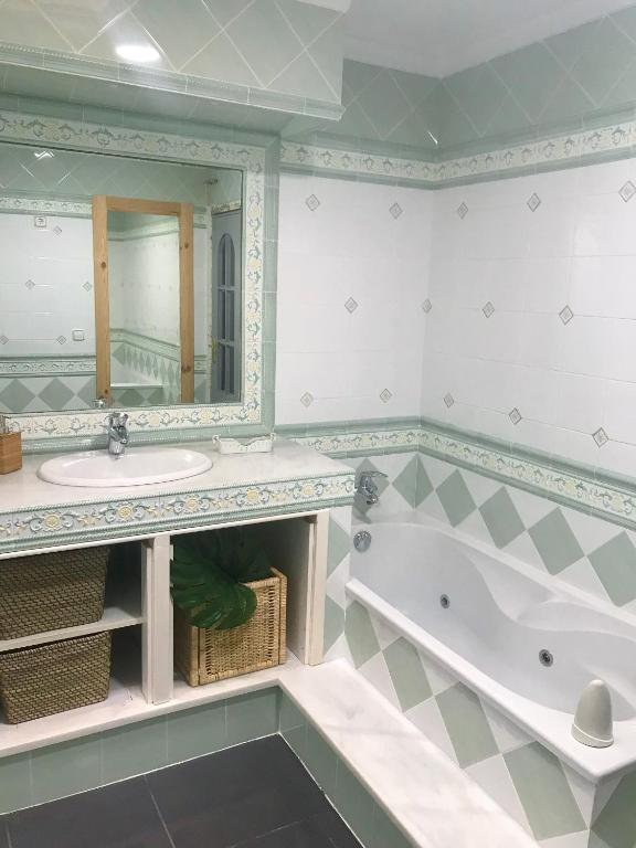 a bathroom with a tub and a sink and a mirror at ROOMQUEO-Only Adults in Barbate