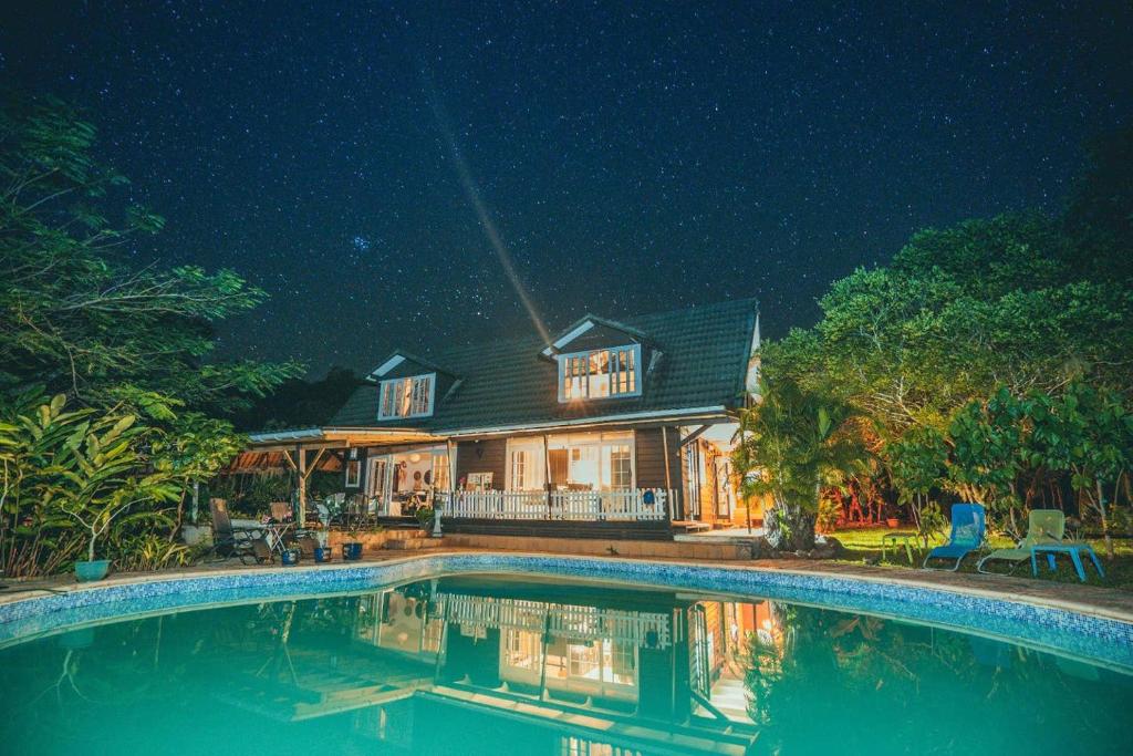 a house with a swimming pool at night at Fare Haurevaiti Moorea in Paopao