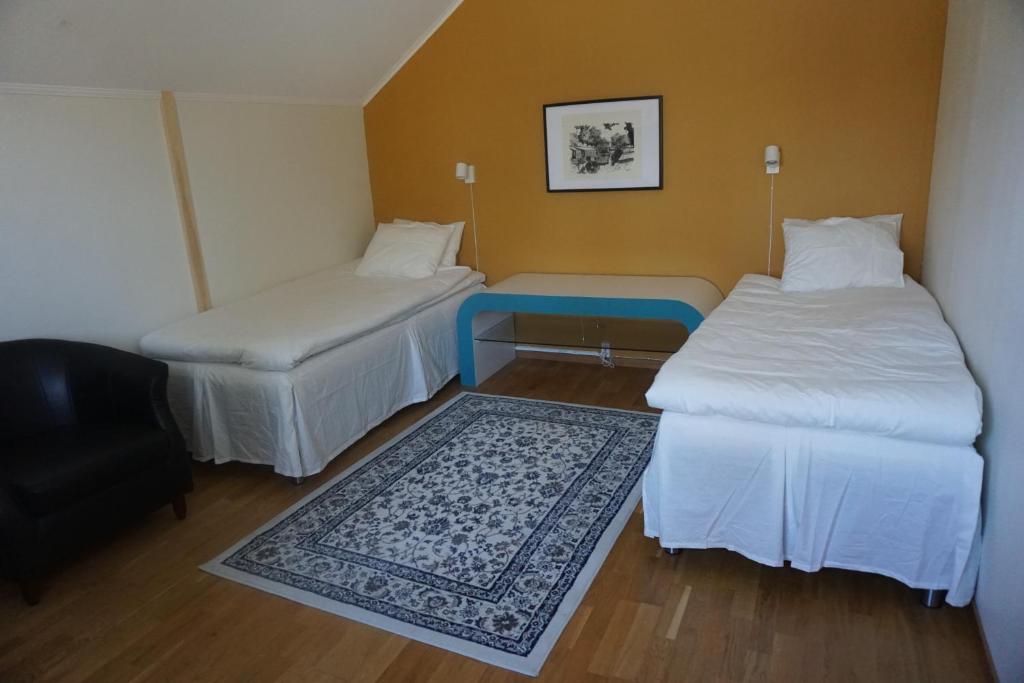 a room with two beds and a blue table at IzKaMaGe Hotel in Västerås