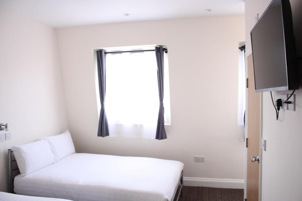 a small room with a bed and a window at Daisy Hotel in London