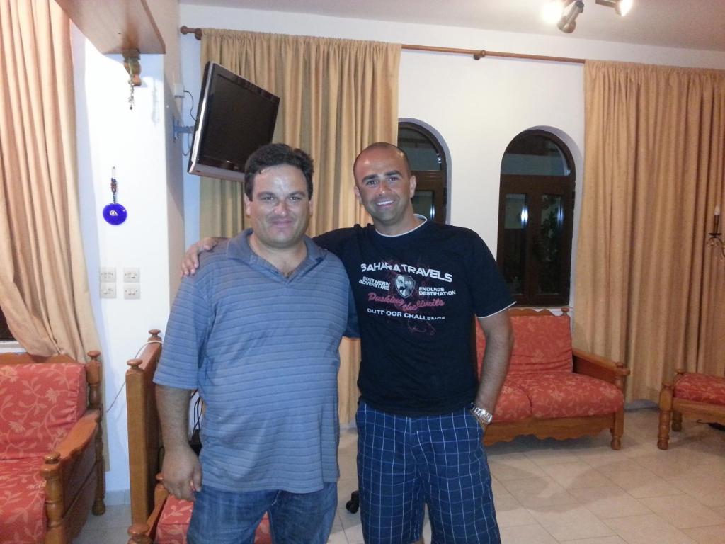 two men standing next to each other in a room at Amaryllis Hotel in Karpathos
