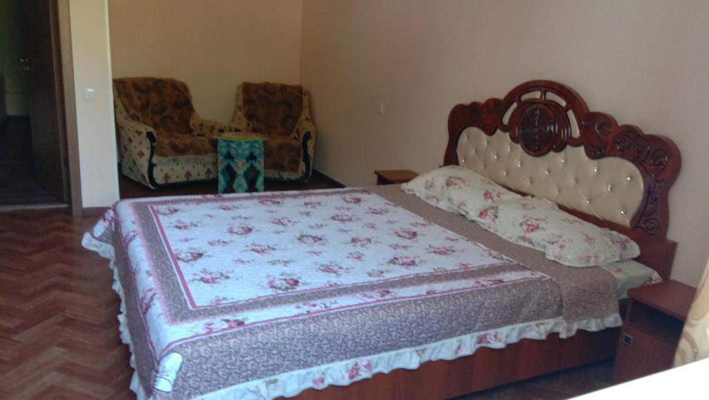 1 dormitorio con 1 cama grande y 1 silla en Guest House Sharq 21, en Khujand