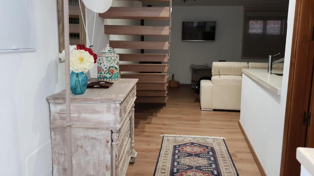 a living room with a table with a vase of flowers at Casa Miguel in Montejaque